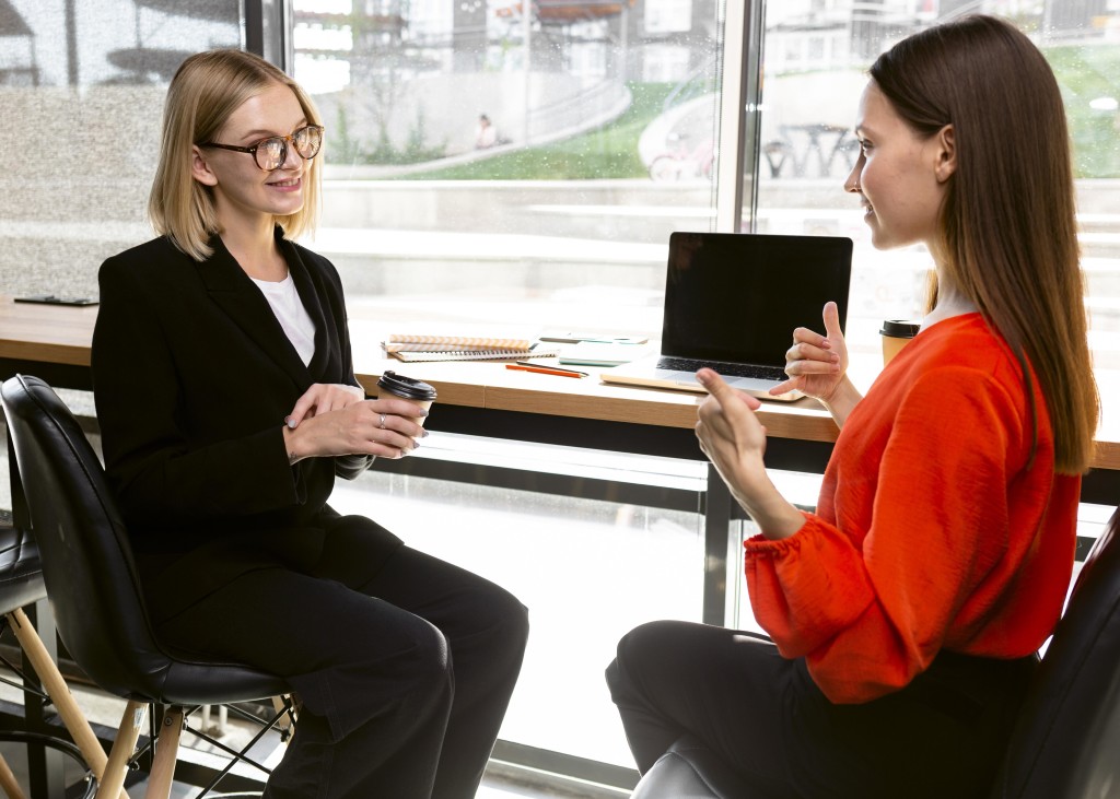 businesswomen-using-sign-language-at-work-to-communicate