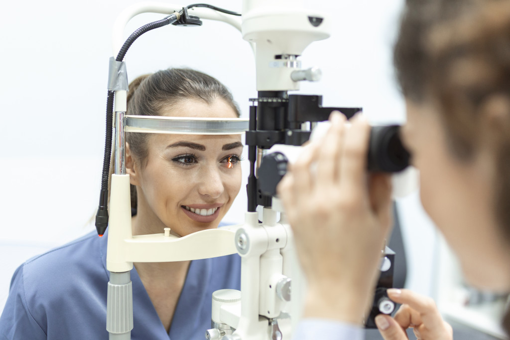 Eye doctor with female patient during an examination in modern clinic. Ophthalmologist is using special medical equipment for eye health