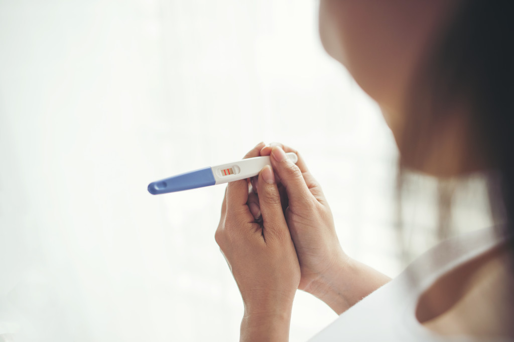 Young woman hand holding pregnancy test