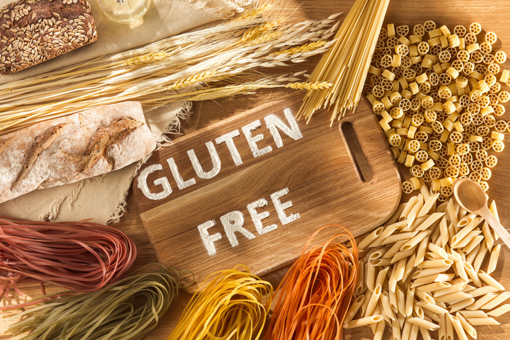 Gluten free food. Various pasta, bread and snacks on wooden background from top view